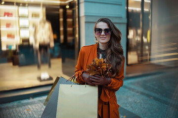 smiling young 40 years old woman in orange trench coat