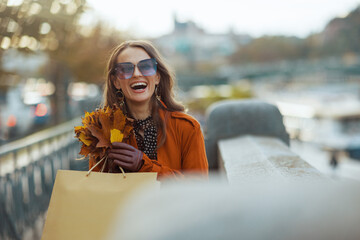 smiling trendy 40 years old woman in brown trench coat