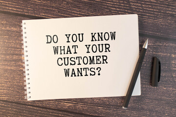 Notebook with text DO YOU KNOW YOUR CUSTOMER on a table with sticks, colored paper clips and...