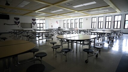 Empty school cafeteria with tables and seats. © Robert Peak