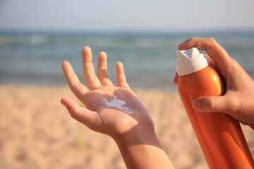 Child applying sunscreen near sea, closeup. Sun protection care