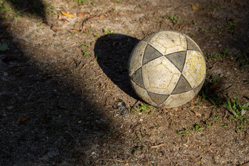 bola de futebol branca e preta bem gasta e usada, parada em cima de um gramado gasto. - obrazy, fototapety, plakaty