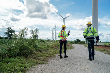 Fototapeta na wymiar Engineers man and woman inspecting construction of WIND TURBINE FARM. WIND TURBINE with an energy storage system operated by Super Energy Corporation. Workers Meeting to check AROUND THE AREA.