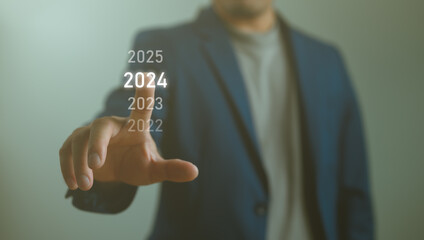 Businessman touching on 2024 wording for marketing monitor and business planing in new year...