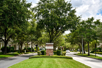 Road leading past entrance sign to Baldwin Park in Orlando, Florida. A tranquil, primarily...