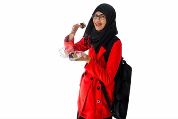 Close up portrait of smiling young Muslim woman wearing black hijab and red jacket with black sling bag open her mouth while holding plastic food plate and sushi. Happy and cheerful expression.