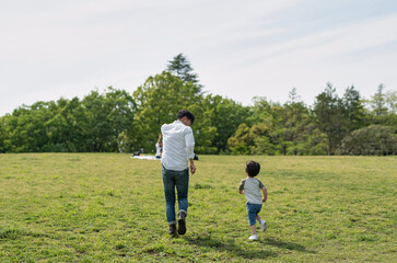 お父さんと一緒に走る子供の後ろ姿 - obrazy, fototapety, plakaty