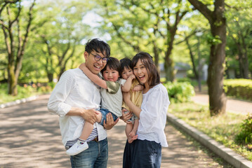 Fototapeta premium 新緑の公園で微笑む家族のポートレート