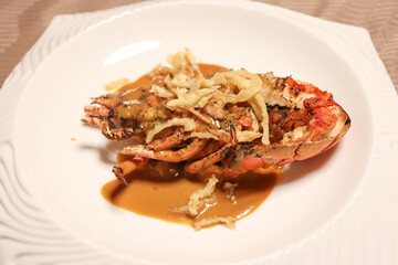 グリルしたエビと香草とソースとフライドチップスの料理