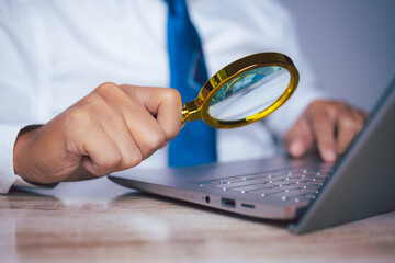 Businessman using magnifying glass searching data. Information in the internet world search technology Search Engine Optimization(SEO).