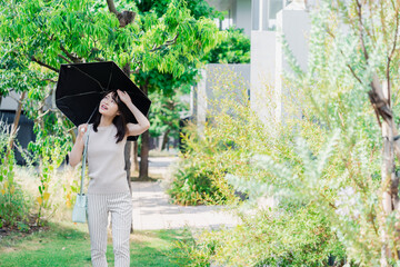 日傘を差して外を歩く若い女性