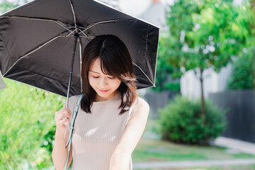 日傘を差して外を歩く若い女性