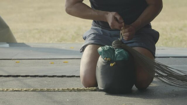 Person Preparing Packed Parachute On The Ground Before Skydiving Activity. medium shot