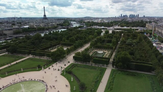 Jardin des Tuileries gardens in Paris with Eiffel tower and La Defence district in background. Aerial drone view