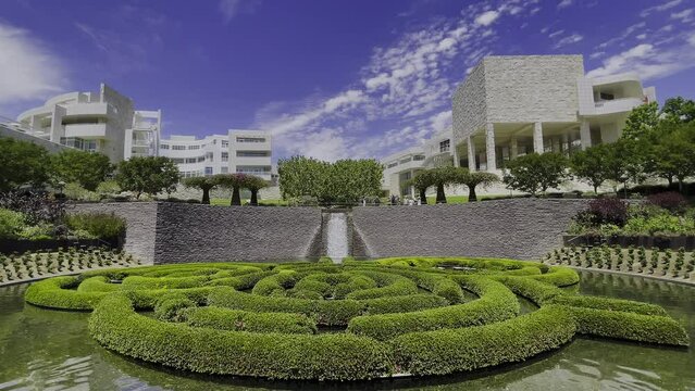 Static shot of the Central Garden at the Getty Center in Los Angeles California with a great view of the fountain waterfall, bushes, buildings, and even a baby duck comes into frame.