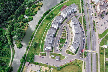 city apartment complex on riverbank. aerial view in cloudy summer day. drone photography.