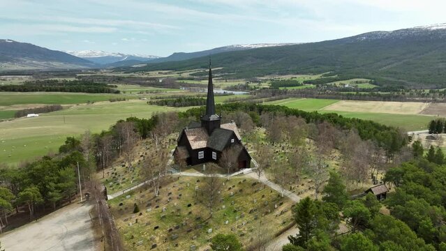 Aerial orbit around beautiful Lesja church made from slatted timber - Innlandet Norway