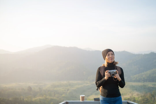 Hiker photographer taking picture of valley with mountains from view point. woman wearing hat stand alone and enjoying freedom and calm inspired travelling. Tourist traveler on background view mockup