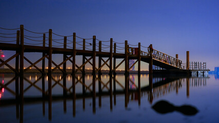 Fototapeta na wymiar Night reflection of wooden Bridge 