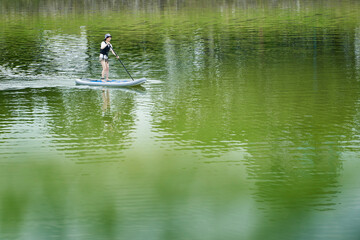 Fototapeta na wymiar 休日の川でサップを楽しむ日本人の女性