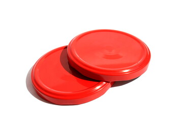 Red iron lids for twisting jars lie on a white background