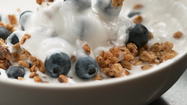 yogurt with blueberries and granola in slow motion