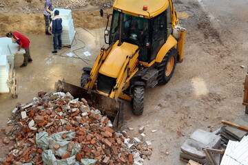 A tractor at a construction site removes debris.