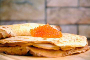 thin wheat pancakes with salmon caviar on the table