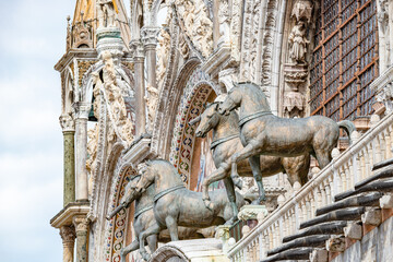 Fototapeta na wymiar View over decoration elements at facade roofs and cupolas of Basilica San Marco with horses in Venice, Italy