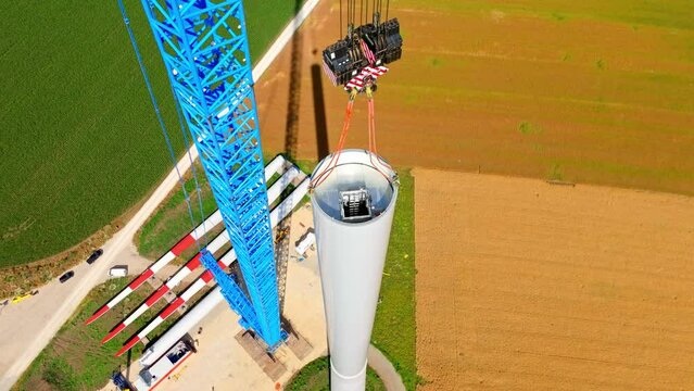 View From Above Of Wind Turbine Tower Erected With Lifting Crane At Farm Field In Austria. aerial orbit