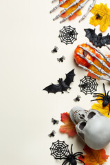 Halloween greeting card with pumpkin, skulls, bony hands and leaves