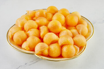 Melon balls cut with a special spoon, in a bowl in the kitchen