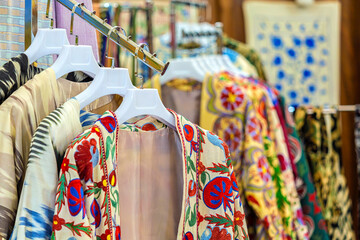 Traditional uzbek multicolored robes (chapan) in souvenir shop. Tashkent, Uzbekistan