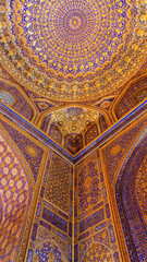 Painted gilded dome of Madrasa Tilya Kori (Registan complex). Arabic text of Koran (sacred book of muslims) used as part of ornament. Gold and blue, vertical. Samarkand, Uzbekistan