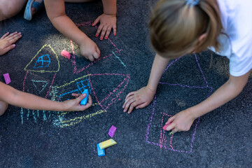 Children draw with crayon on asphalt road outdoor