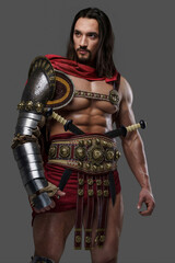 Fototapeta na wymiar Majestic gladiator in sleek light armor and red cloak against a gray background