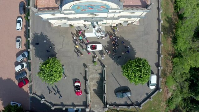 Oldtimer for bride and groom in front of church, wedding celebration, aerial 