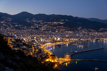 Night city. Alanya, Turkey. Beautiful lights of night city. View of Alanya harbor form Alanya peninsula. Turkish Riviera by night.