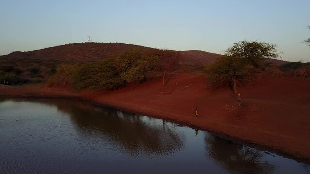 Aerial view of Borana child running along a water reservoir Oromia Ethiopia