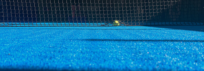 Padel court details with blue floor, net details and shadows