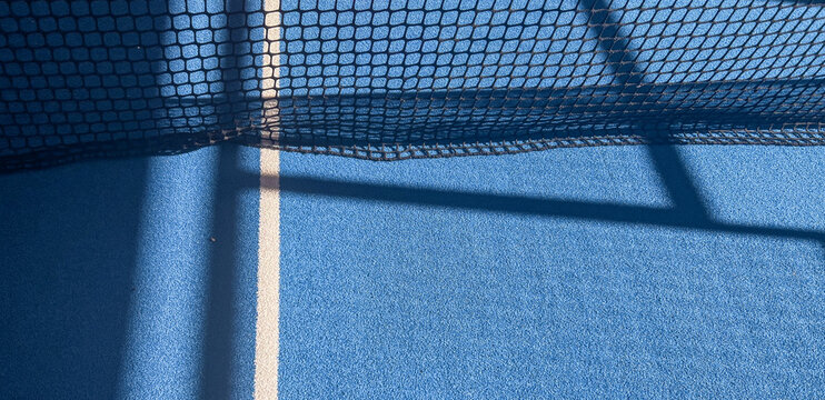 Padel court details with blue floor, net details and shadows