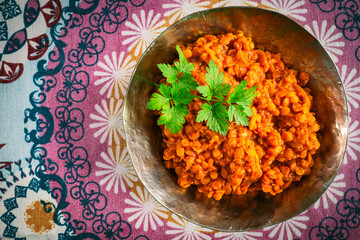 rote Linsen Essen im Teller, Schale. Zubereitet als Dal, Salat, Curry mit Kokosmilch und indischen Gewürzen. Dekorativ angerichtet mit glatter Petersilie