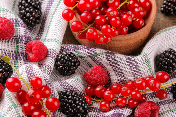 Various berries, raspberries, blueberries, currants, blackberries on a napkin.