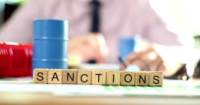 Barrels of oil against background of text of sanctions and embargo of Russian oil. Sanctions energy embargo and economic fuel crisis