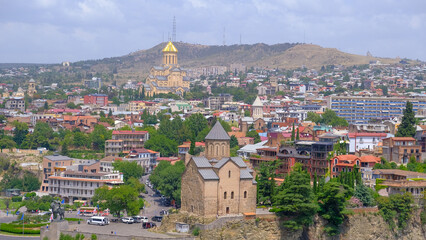 Fototapeta premium landscape old Town and houses of Tbilisi , Georgia from Above Narikala fort: Holy Trinity Cathedral, Tranquil Lake Views, Peace Bridge Charm, Nmetekhi St. Virgin Church Heritage Zion Cathedral Majesty