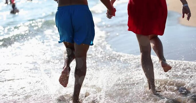 Happy young couple running on sea beach. Emotions happiness love joy honeymoon on vacation