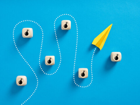 Paper plane passes through the wooden cubes with bomb symbol.