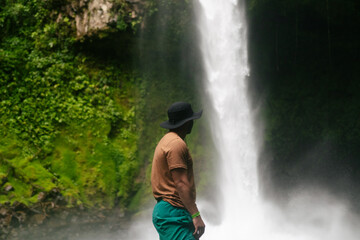 Fototapeta na wymiar Young man looking at a waterfall