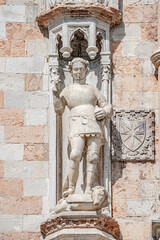 Venice, Italy - Ancient facade sculpture of a knight with a spire killing a dragon as the top decoration of Doge's Palace in Venice, Italy