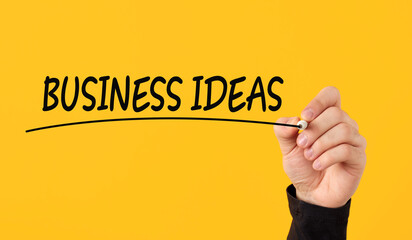 Creative business ideas concept. Male hand draws a line under the word business ideas